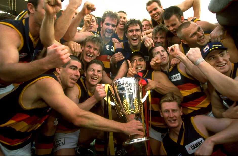 AFL 1998 Grand Final - North Melbourne v Adelaide Adelaide Crows players celebrate with the Premiership Cup after winning the 1998 AFL Grand Final between North Melbourne and the Adelaide Crows at the Melbourne Cricket Ground in Melbourne on September 26, 1998.